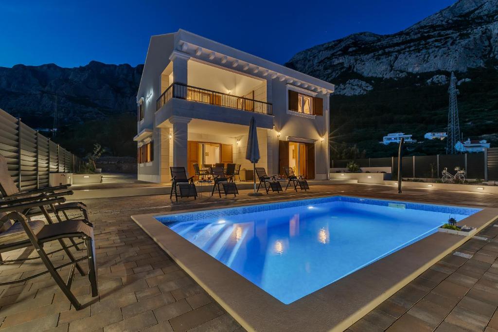 a villa with a swimming pool in front of a house at NEW! Milan's House with pool, Mediterranean in Makarska