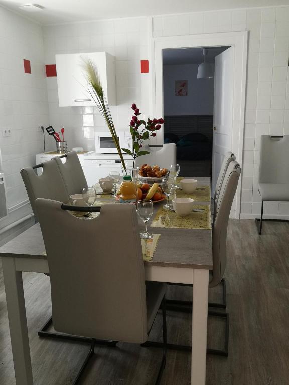 - une table à manger avec des chaises et une table avec des fruits dans l'établissement Charmant logis dans une construction de caractère, à Gérardmer