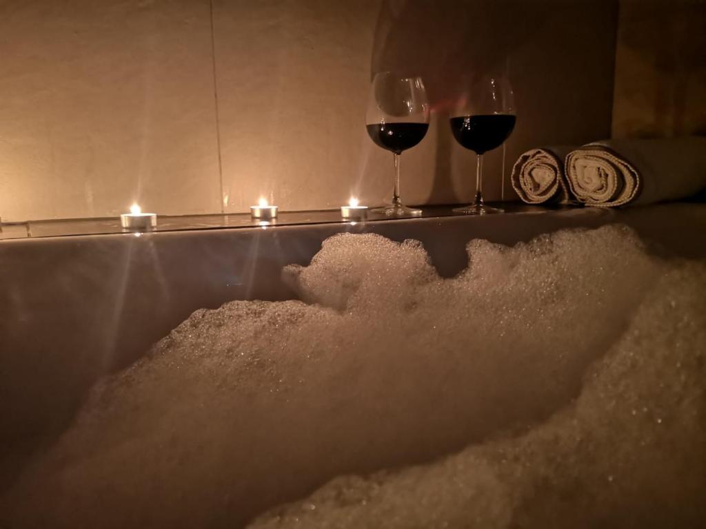 una bañera llena de nieve junto a dos copas de vino en Apartamenty LENA 3, en Racibórz