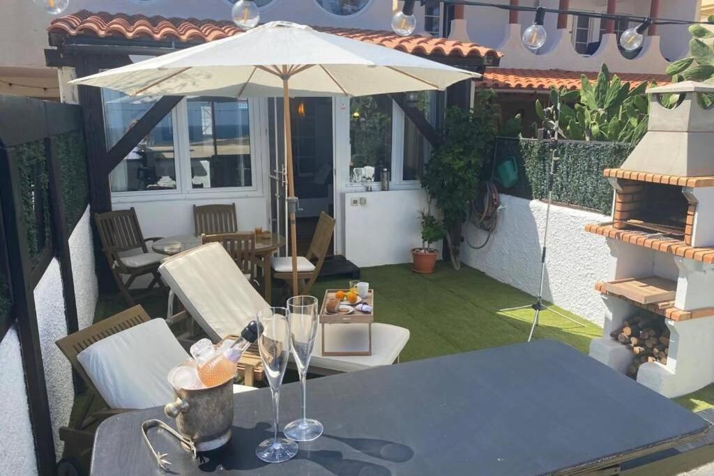 eine Terrasse mit einem Tisch und einem Sonnenschirm in der Unterkunft Old King's beach house in Pájara