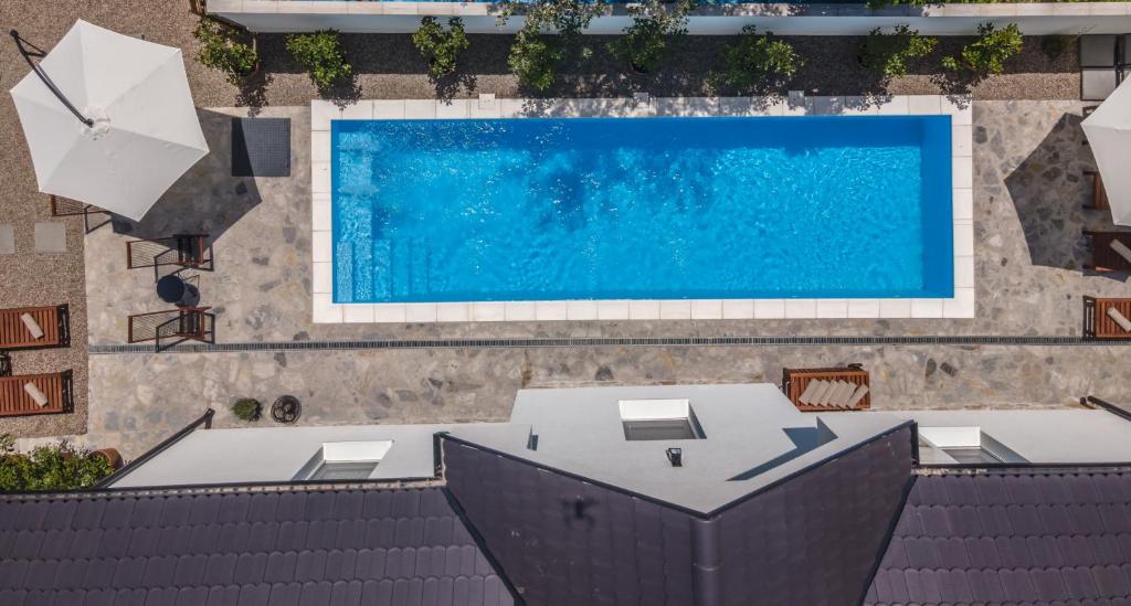 an overhead view of a pool with a table and an umbrella at Vila Pobeda in Banja Koviljača