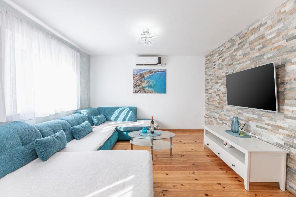 salon z niebieską kanapą i ceglaną ścianą w obiekcie Apartment Otasevic 1 w mieście Tivat