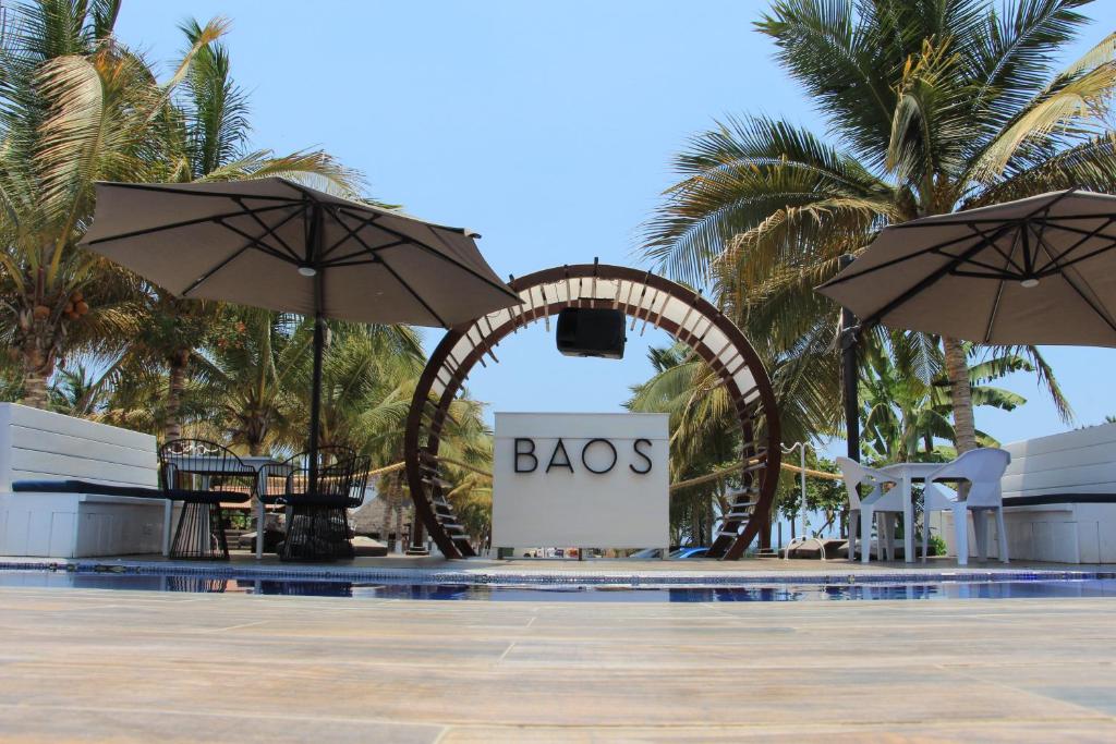 ein Pool mit einem Schild, das Babos mit Sonnenschirmen liest in der Unterkunft BAOS in San-Blas-Inseln