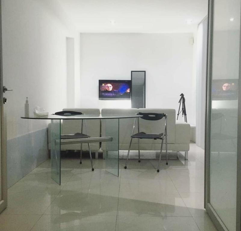 a glass table and two chairs in a room at Apartment level 1 Elegant primer piso Edificio de Apartamentos Moderno en San Borja Lima in Lima