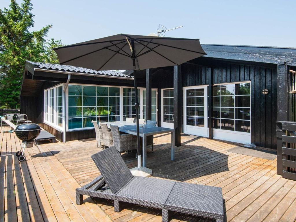 a patio with an umbrella and a table and chairs at 8 person holiday home in Ringk bing in Klegod