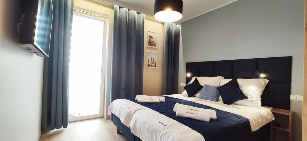 a bedroom with a large bed with blue and white at LuxHoliday in Grzybowo