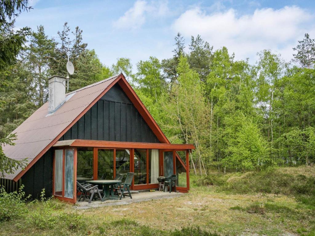 Spidsegårdにある5 person holiday home in Nexのテーブルと椅子が備わる森の中のキャビン