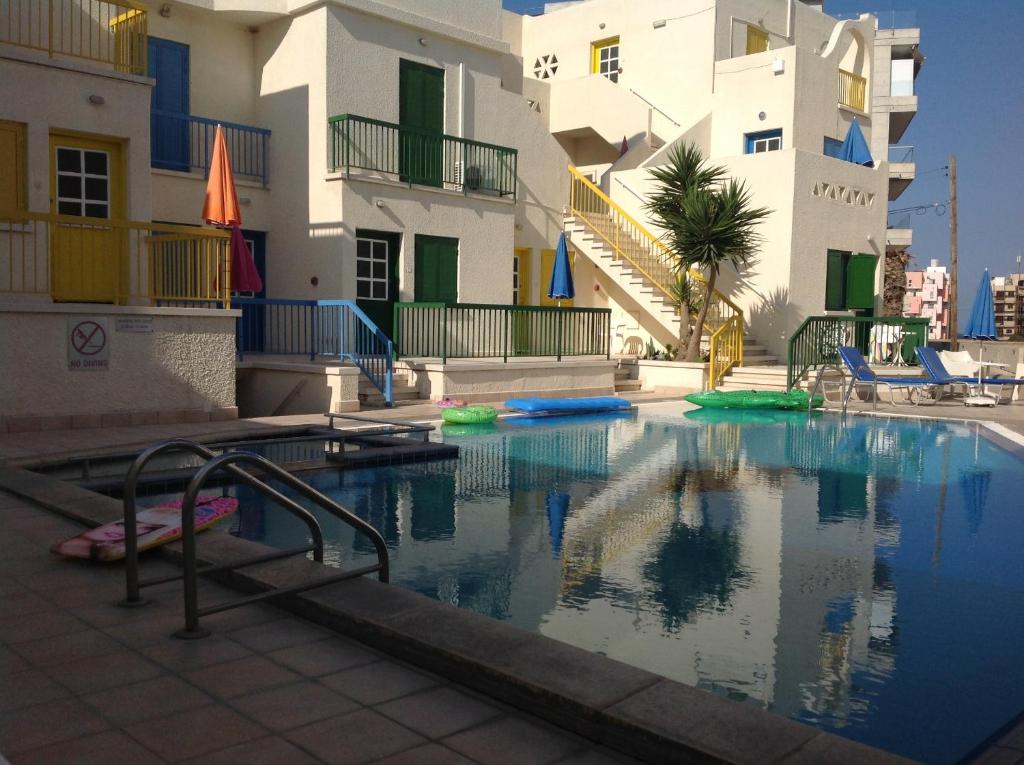 a swimming pool in front of a building at Sea N Lake View Hotel Apartments in Larnaca