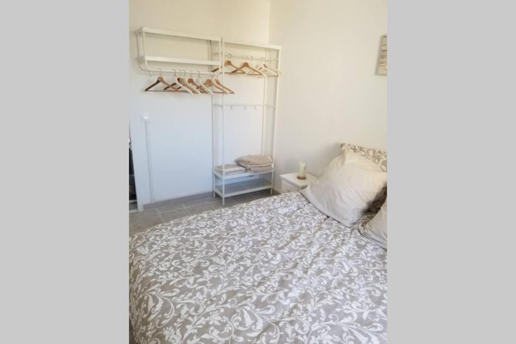 um quarto com uma cama com uma colcha cinzenta e branca em Calanques de Sormiou em Marselha