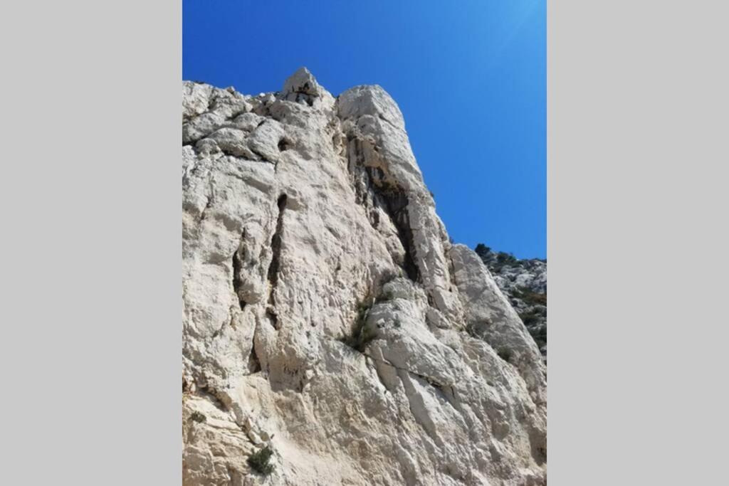 a rock mountain with a blue sky in the background at Calanques de Sormiou in Marseille