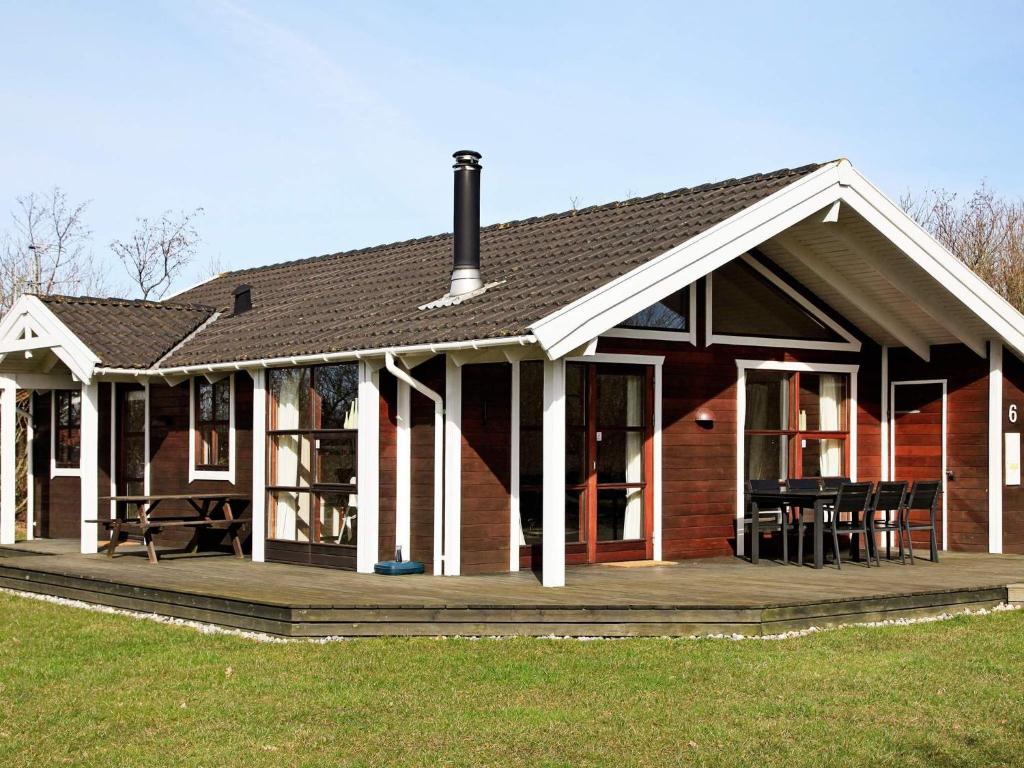 a house with a porch and a wooden deck at Two-Bedroom Holiday home in Hemmet 3 in Hemmet
