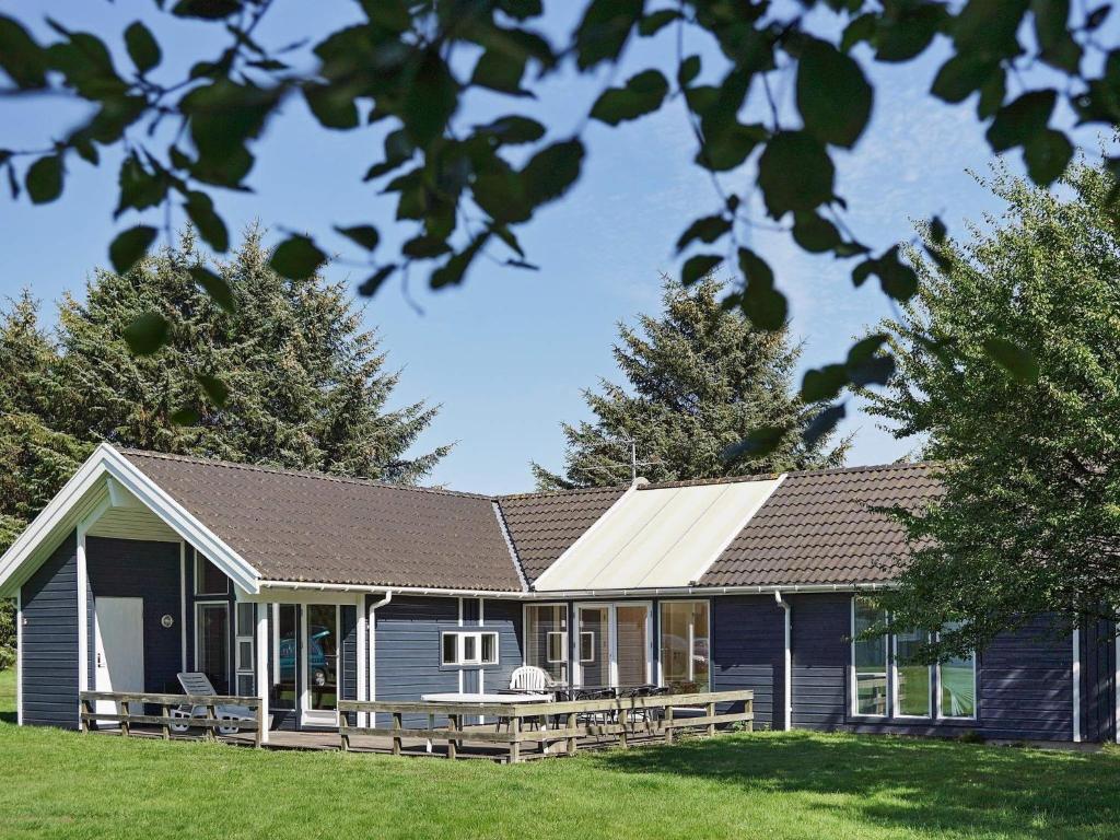 a blue house with a white roof and a yard at 12 person holiday home in Aakirkeby in Vester Sømarken