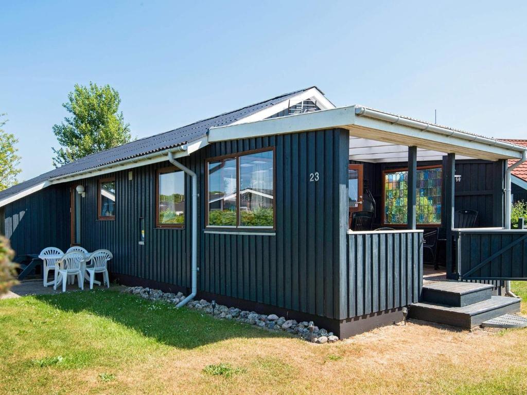 Sønderbyにある5 person holiday home in Juelsmindeの庭にテーブルと椅子を配置した緑の家