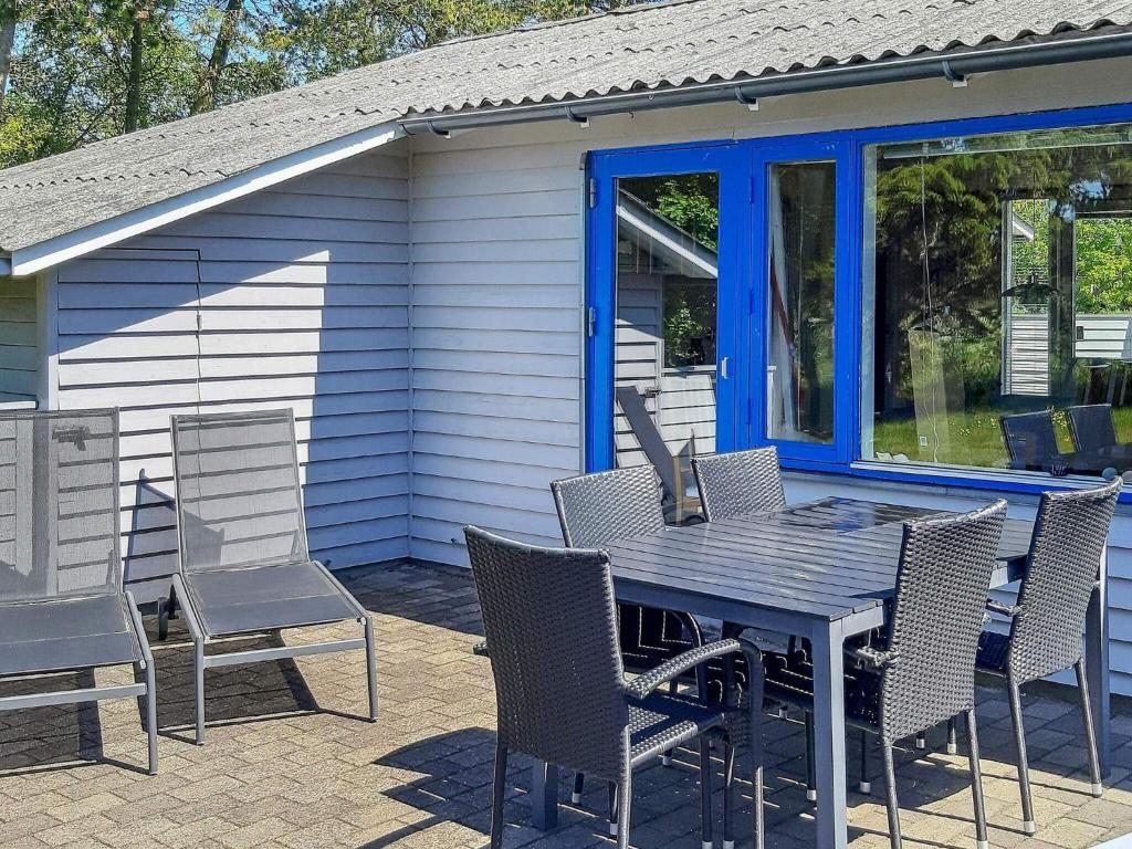 una mesa y sillas en un patio con una casa en 4 person holiday home in S by, en Nordost