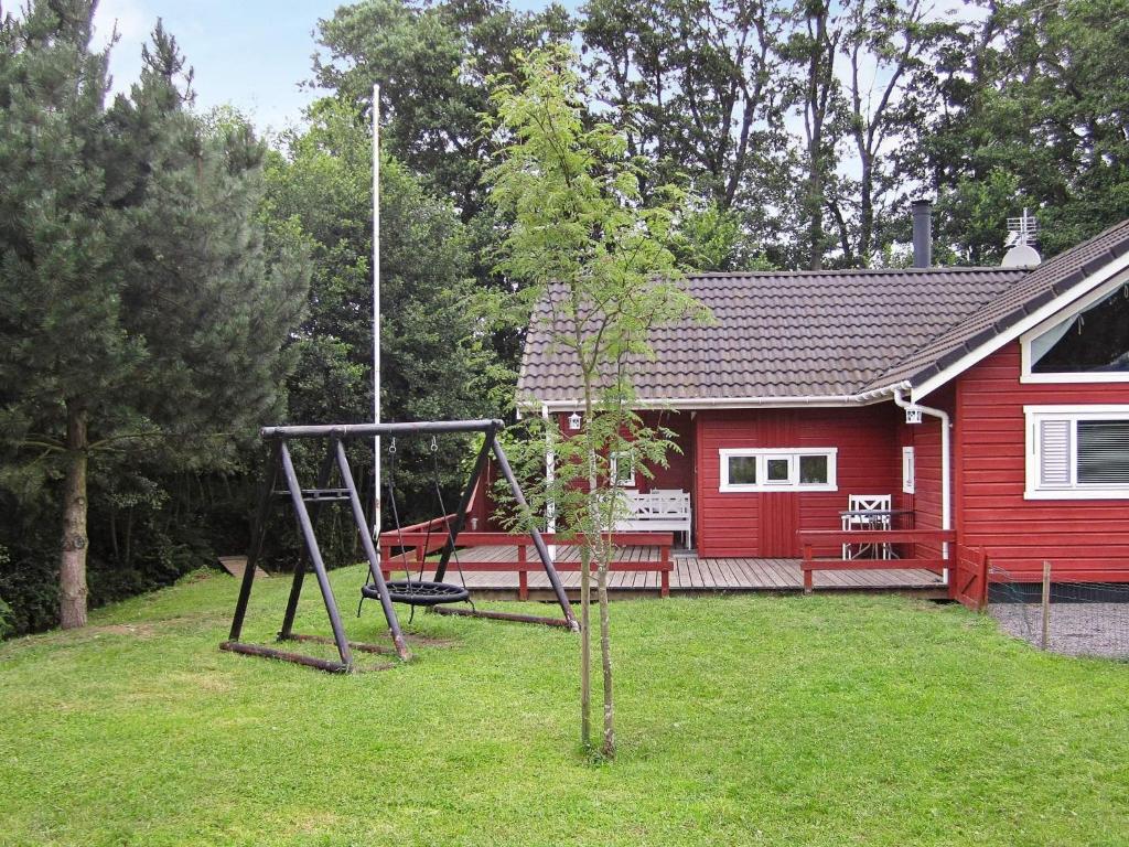 Vester Sømarkenにある6 person holiday home in Aakirkebyの赤い家の前の遊び場
