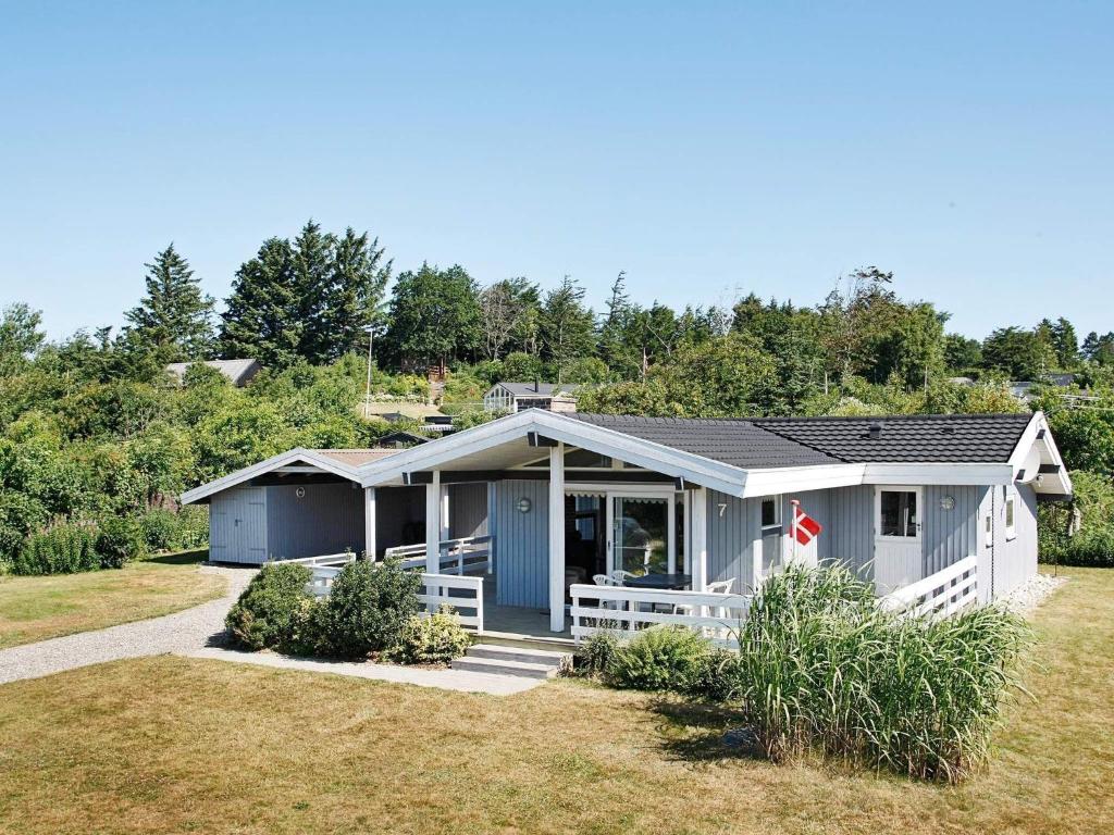 a small house with a porch on a lawn at Three-Bedroom Holiday home in Spøttrup 3 in Lihme