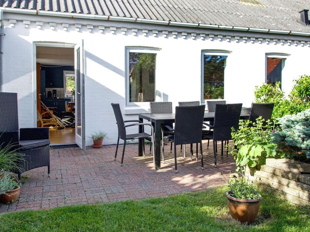 une terrasse avec une table noire et des chaises. dans l'établissement 7 person holiday home in Lemvig, à Lemvig