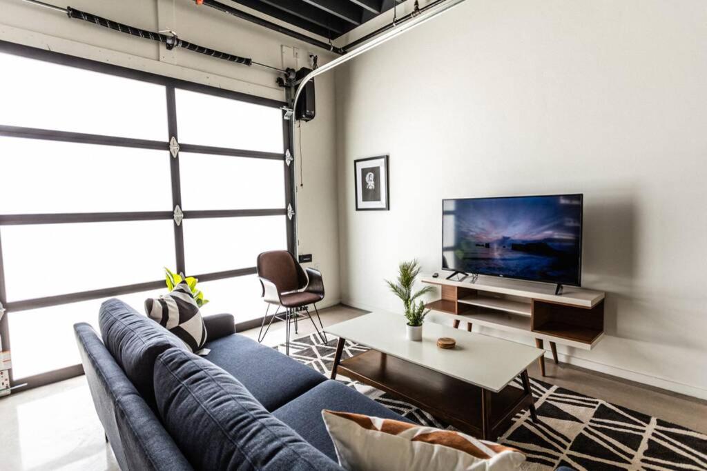 a living room with a blue couch and a tv at Amazing 1BR Loft Located Downtown in Tucson