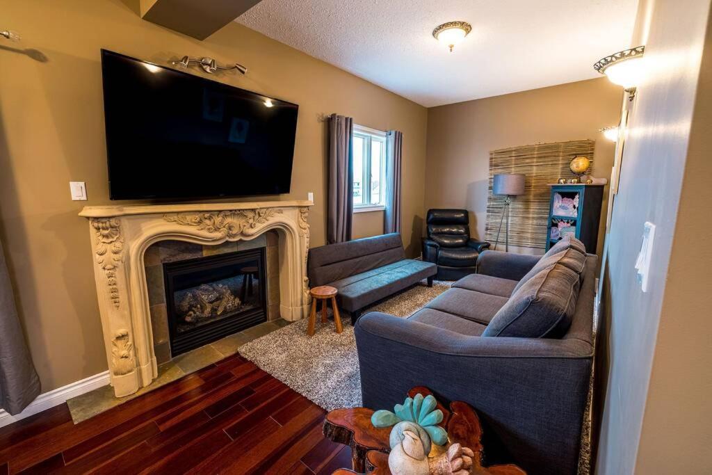 a living room with a television and a fireplace at The River Blossom Suite - Downtown in Drumheller