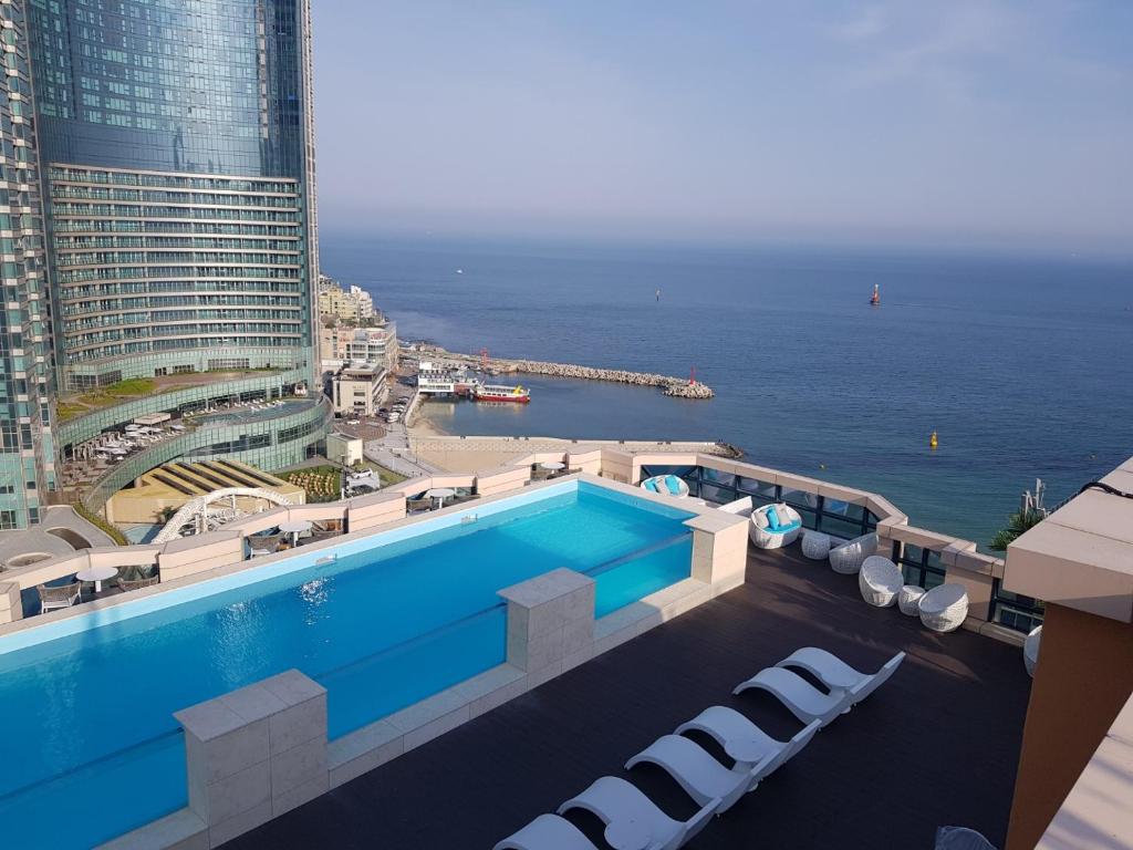 a swimming pool with a view of the ocean at Haeundae Central Hotel in Busan