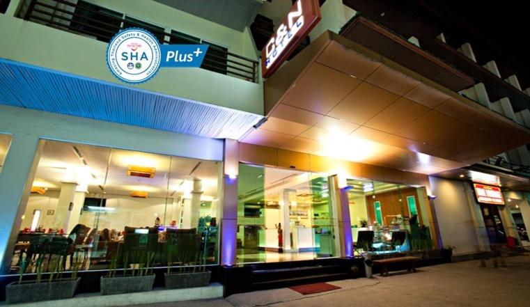 una tienda frente a un centro comercial por la noche en C & N Hotel - SHA Extra Plus, en Patong Beach