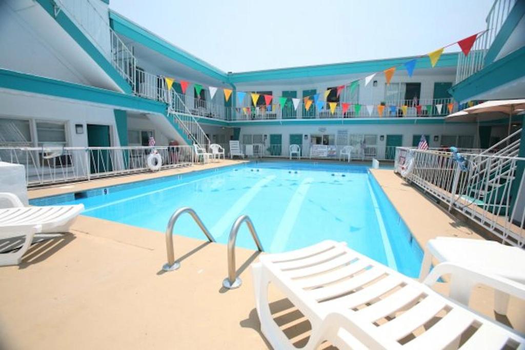 a large swimming pool with two lounge chairs in a building at El Ray Motel in Wildwood