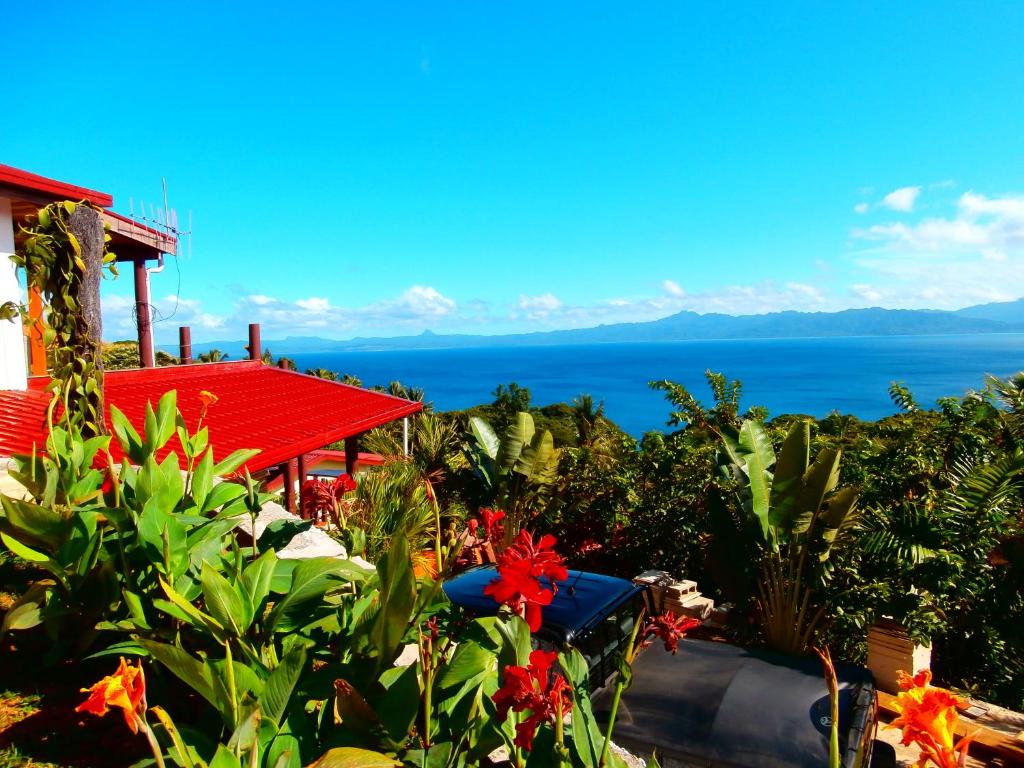 a view of the ocean from a house with flowers at Korovesi Sunshine Villas in Savusavu