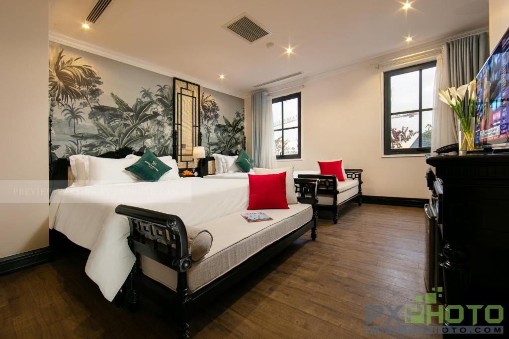 een slaapkamer met een groot wit bed met rode kussens bij Green Suites Hotel in Ha Long
