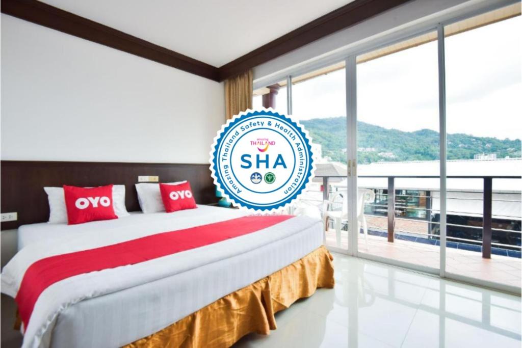 a large bed in a room with a large window at OYO 389 Sira Boutique Residence in Patong Beach