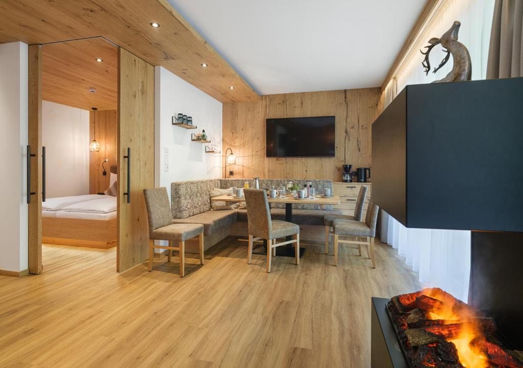 a living room with a couch and a table and chairs at Alpen-Nest Großarl in Grossarl