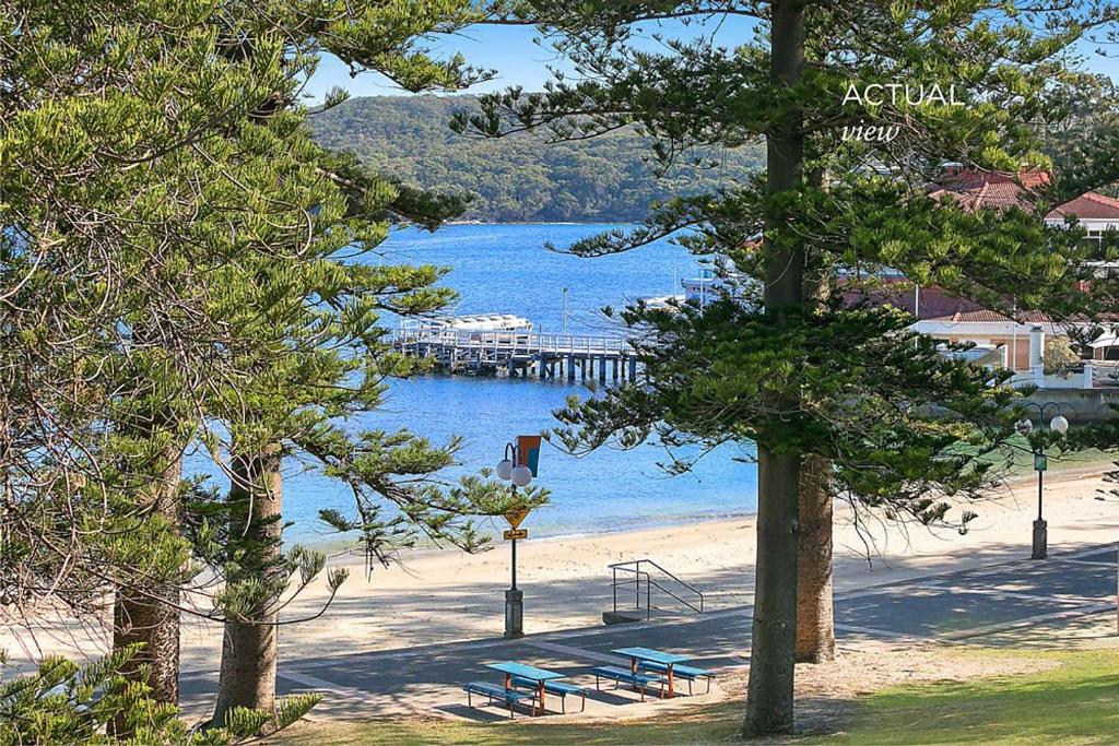 a beach with benches and a dock in the water at Best location in Manly Harbour view in Sydney