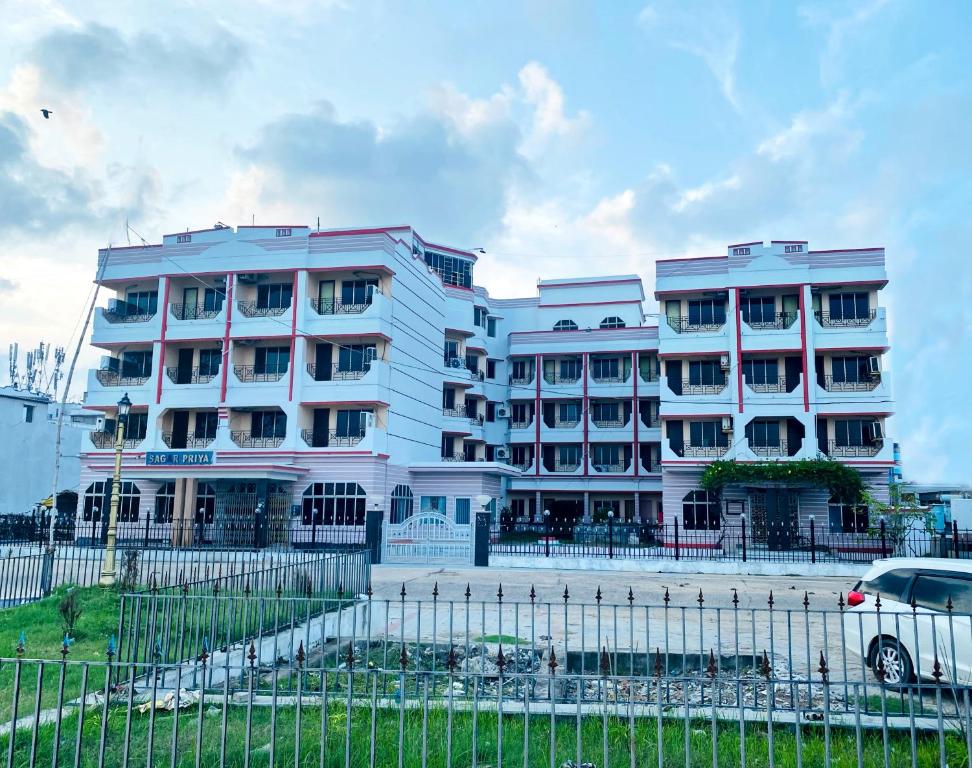 een wit gebouw met een hek ervoor bij Hotel SagarPriya in Digha