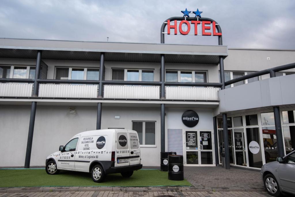 ミエレツにあるHotel Reg Benzのホテル前に停車する白いバン