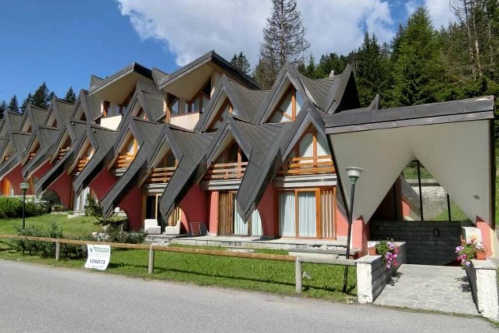 a row of houses with black roof at APPARTAMENTO A MADONNA DI CAMPIGLIO in Madonna di Campiglio