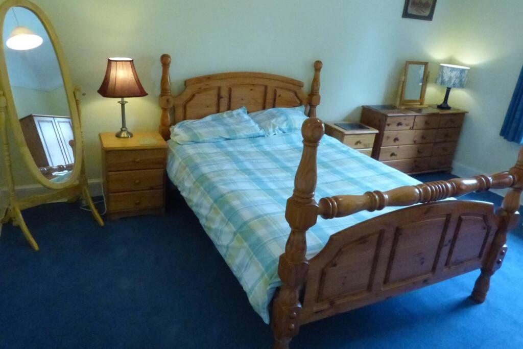 a bedroom with a bed and a dresser and a mirror at Pitlochry North Wing Apartment, very central in Pitlochry