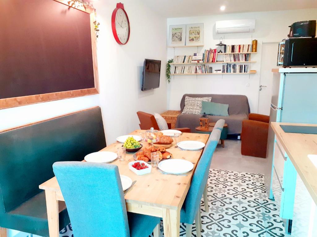 uma cozinha e sala de estar com uma mesa de madeira e cadeiras em Esprit Bistrot / Rent4night Grenoble em Grenoble