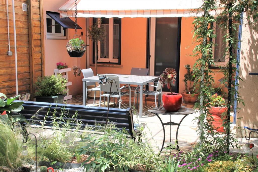 a patio with a table and chairs and plants at Maison Toulousaine avec jardin in Toulouse
