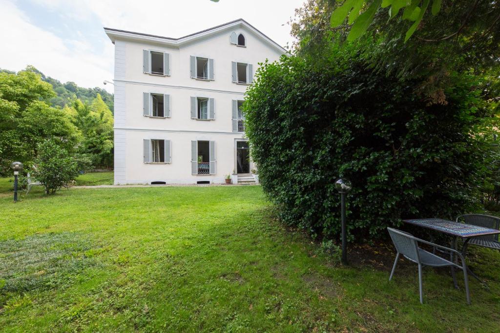 a white house with a bench in front of it at Villa Cardano Maccagno close to every destination in Maccagno Inferiore