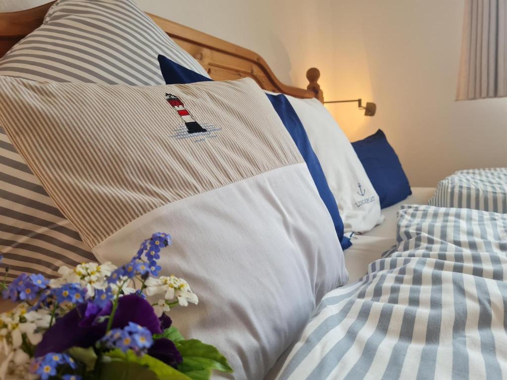 - un lit avec des oreillers et des fleurs bleus et blancs dans l'établissement Ferienhaus Vestvind, à Sankt Peter-Ording
