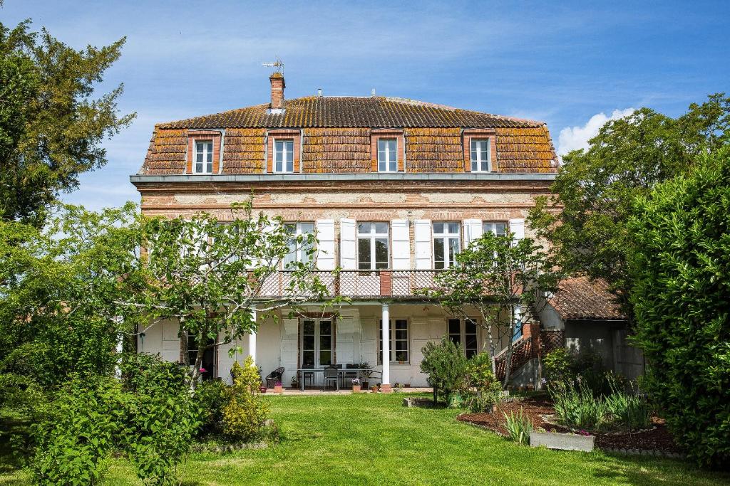 una antigua casa de ladrillo con un gran patio en Au Coeur des Eléments, en Saint-Nicolas-de-la-Grave