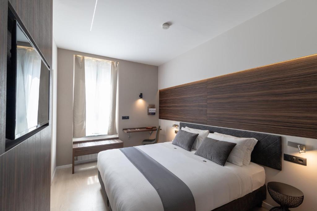 a bedroom with a large bed with a wooden headboard at Aiello Hotels - Centrale in Milan