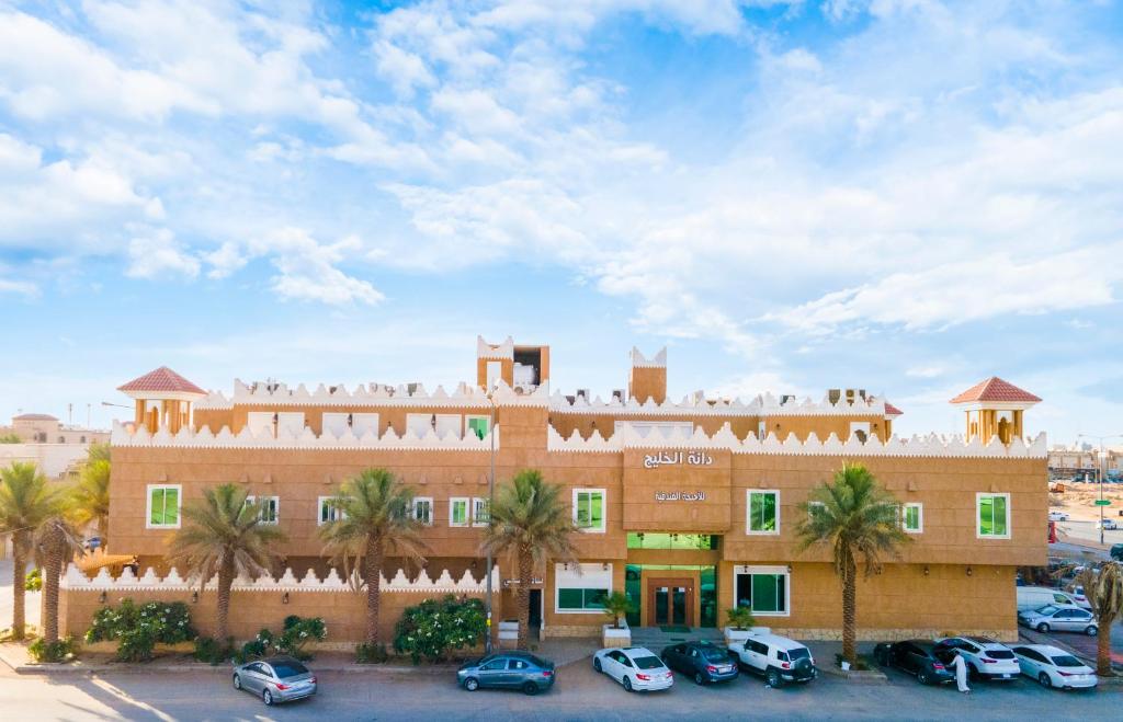 a large building with cars parked in a parking lot at فندق آل متعب سويتس التراثي in Riyadh