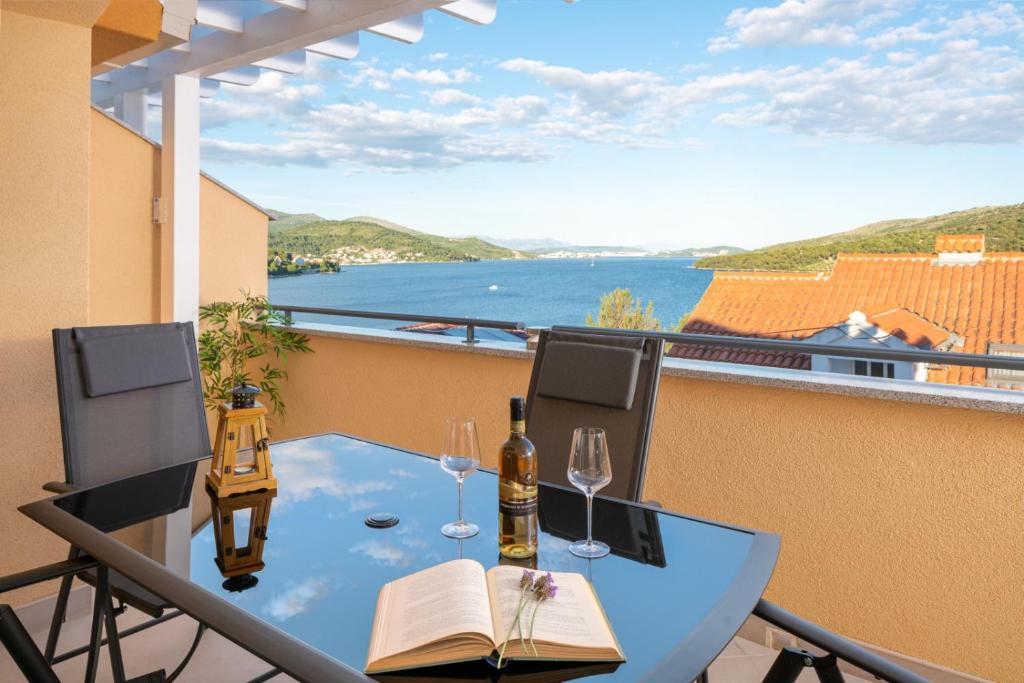 - une table avec des verres à vin et un livre sur un balcon dans l'établissement VILLA A, à Marina