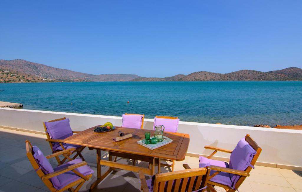 a table and chairs on the deck of a boat at Kristallia - Elounda seafront vacation rental in Elounda