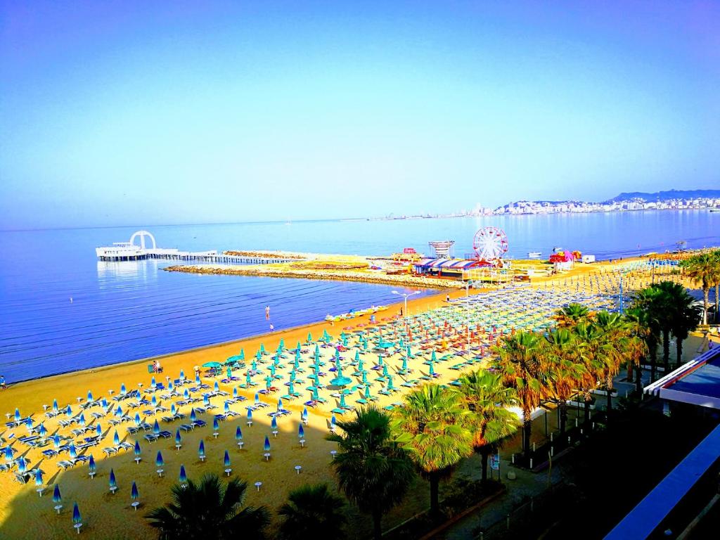 uma praia com guarda-sóis e palmeiras e o oceano em Turtle Apartment em Durrës