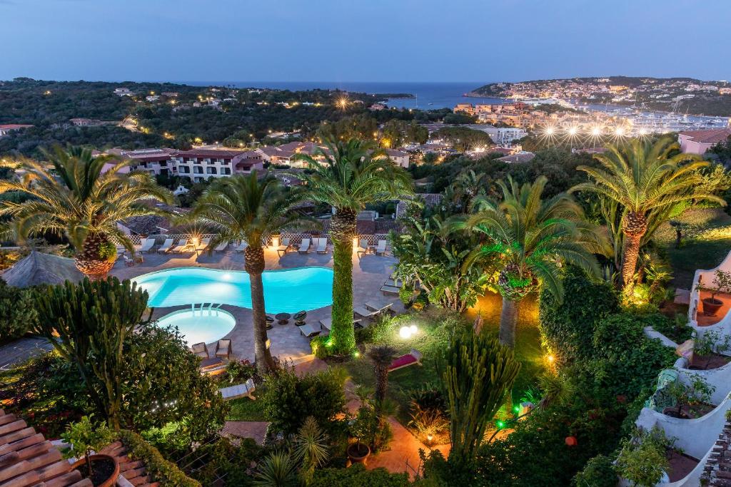 a view of a resort with palm trees at night at Hotel Balocco in Porto Cervo