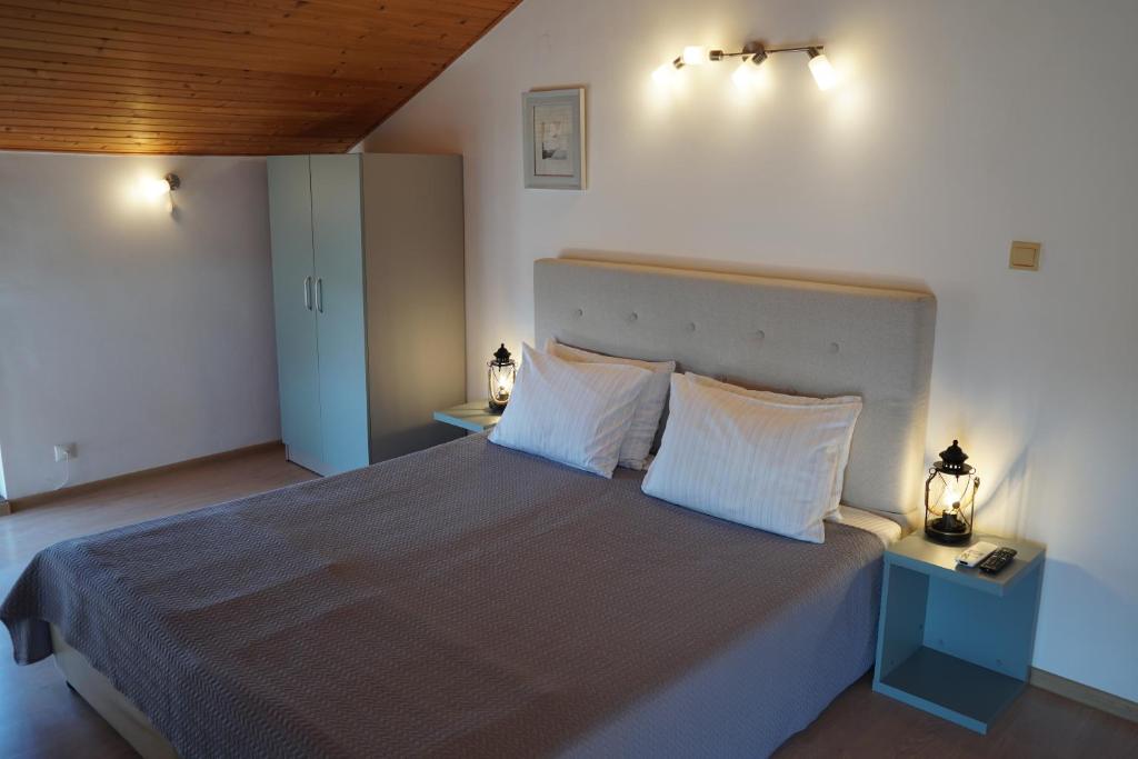 a bedroom with a large bed with two white pillows at Guest House Lambovi in Nesebar