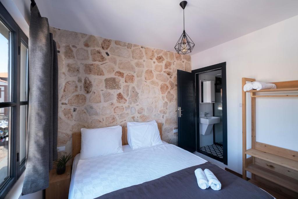 a bedroom with a bed and a stone wall at Solo Boutique Hotel in Antalya
