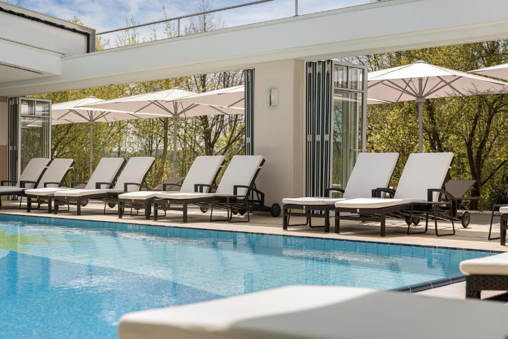 a pool with chaise lounge chairs and a row ofvation at Hotel Sonnengut Wellness - Therme - Spa in Bad Birnbach