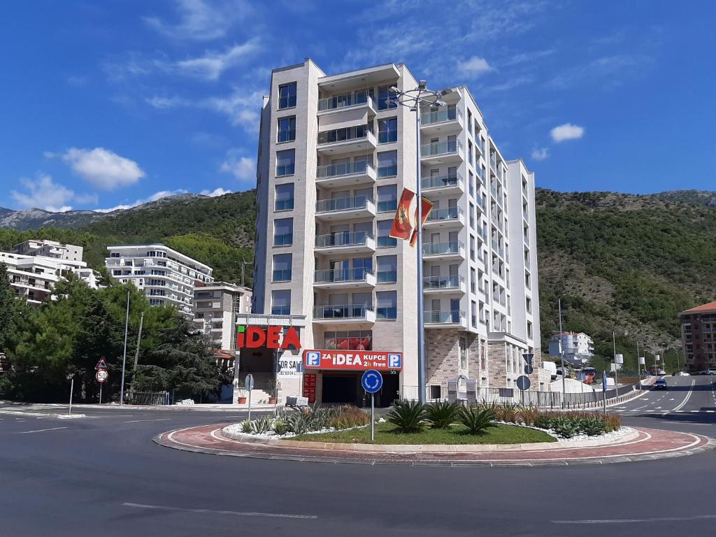 ein großes weißes Apartmenthaus an der Straßenseite in der Unterkunft Lux Apartment Talija in Budva